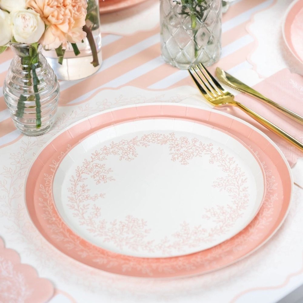 Pink dinner plate styled with flowers and striped table runner