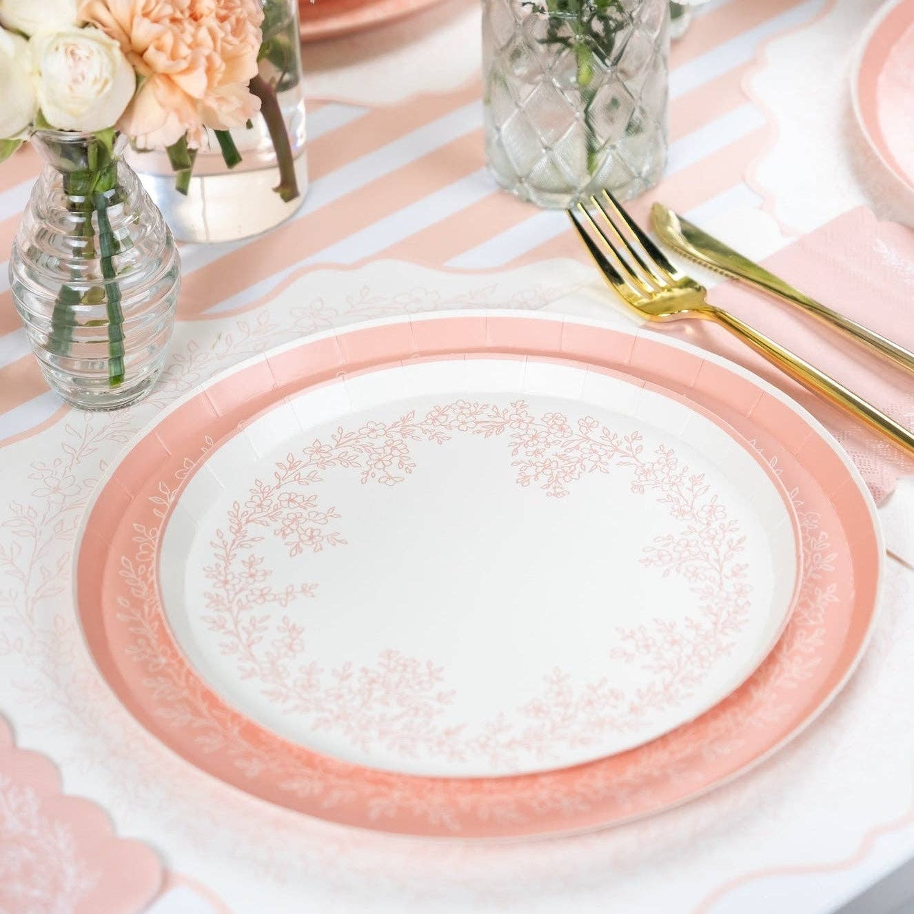 Pink floral plates styled with flowers and striped table runner
