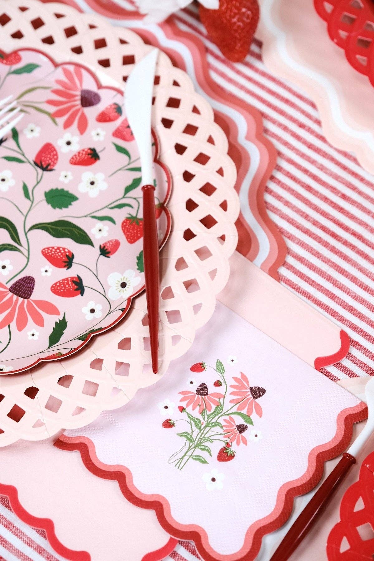 Strawberry Cocktail Napkin layered under a red knife as part of a Strawberry Core Aesthetic Party setting.