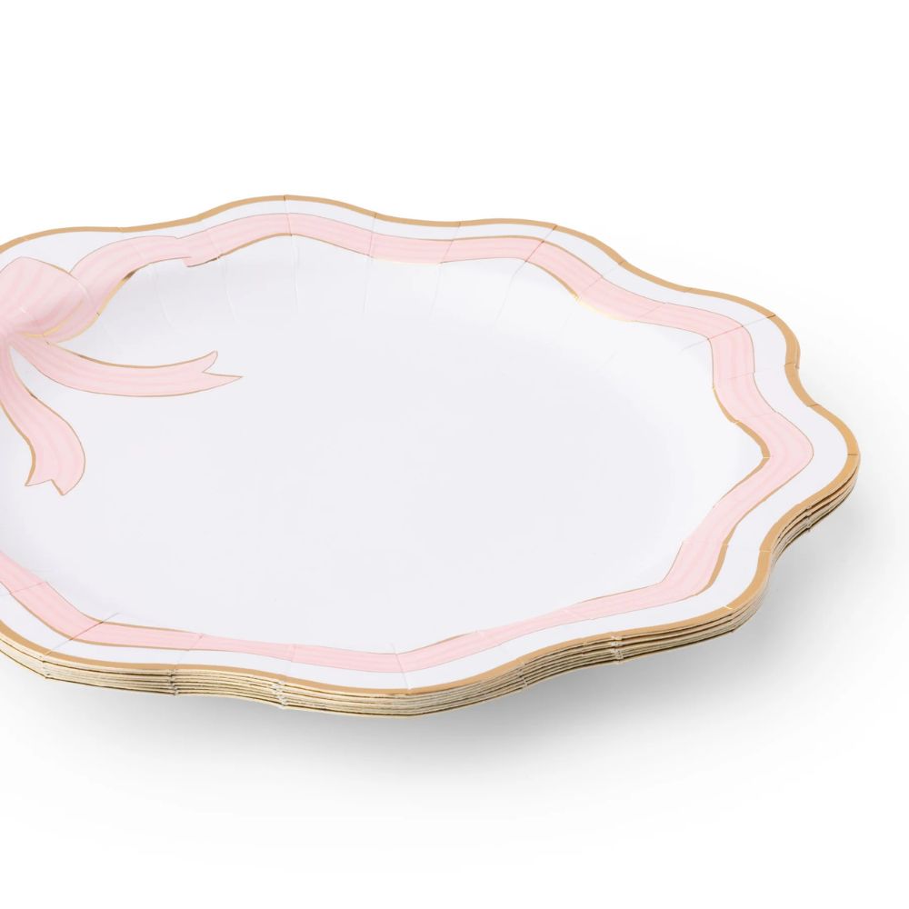 Stack of pink and gold bow dinner plates with scalloped edges