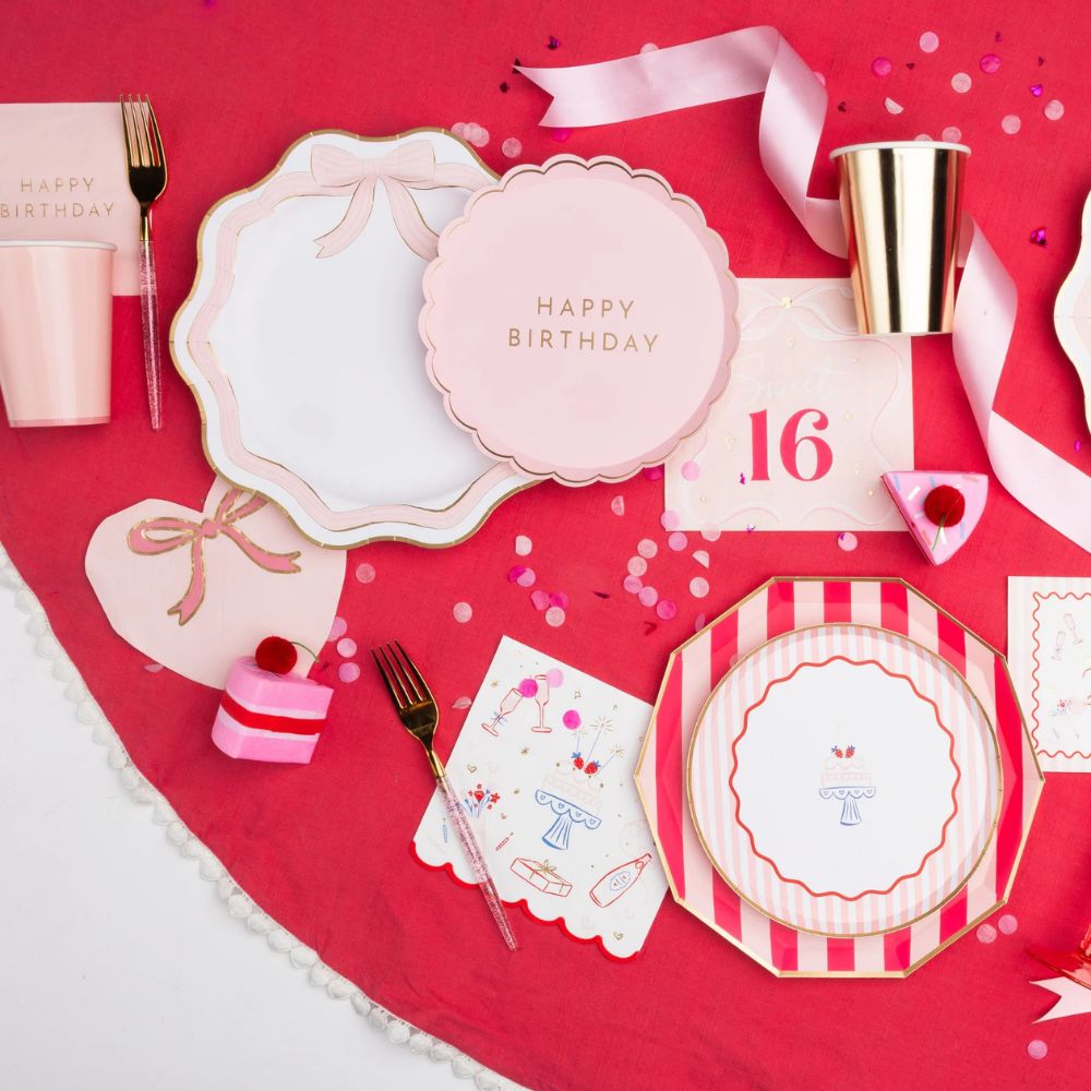 Pink and gold party table with bow plates and Sweet 16 birthday decor