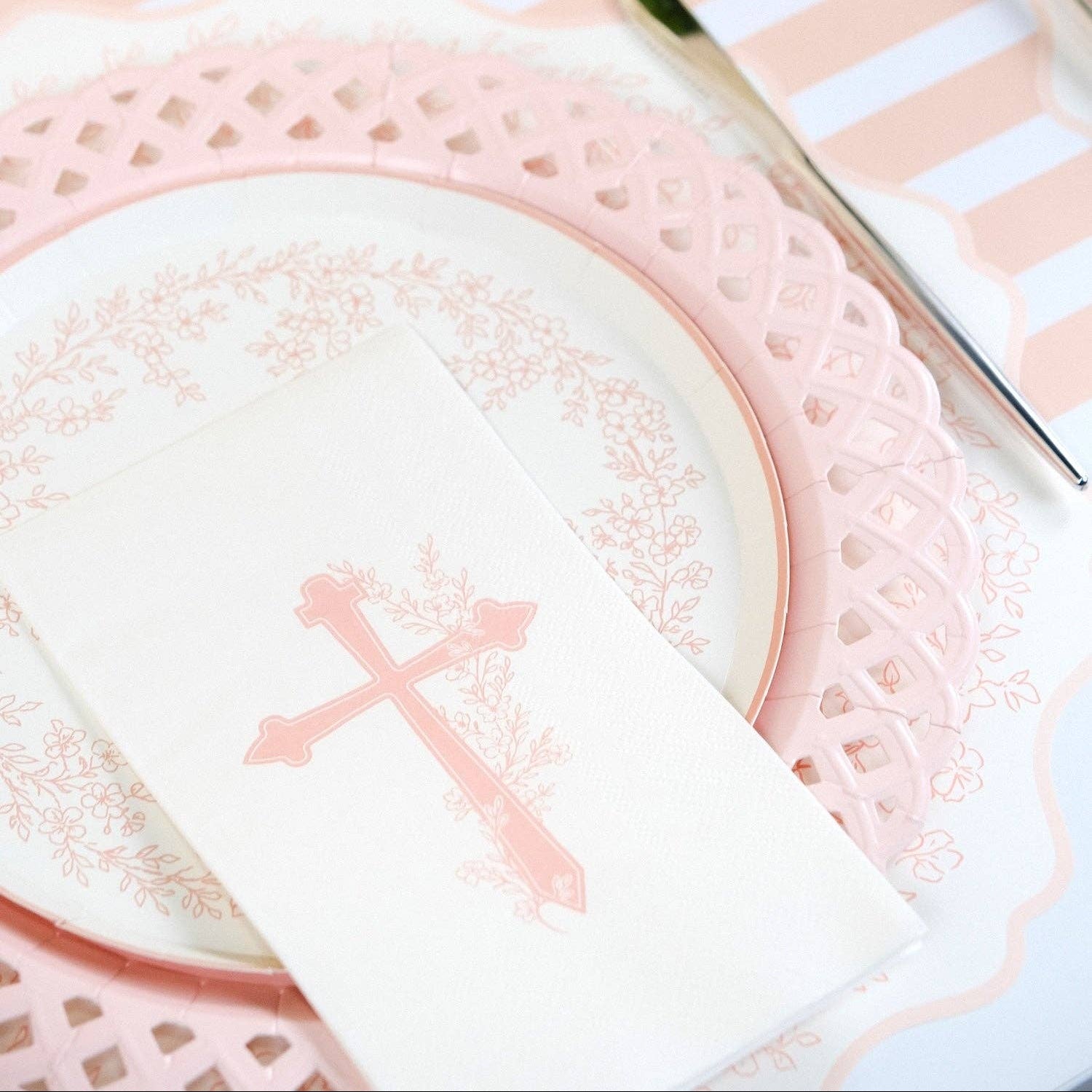 A detailed view of the delicate lattice work on the rim of a pink heirloom aesthetic paper plate.