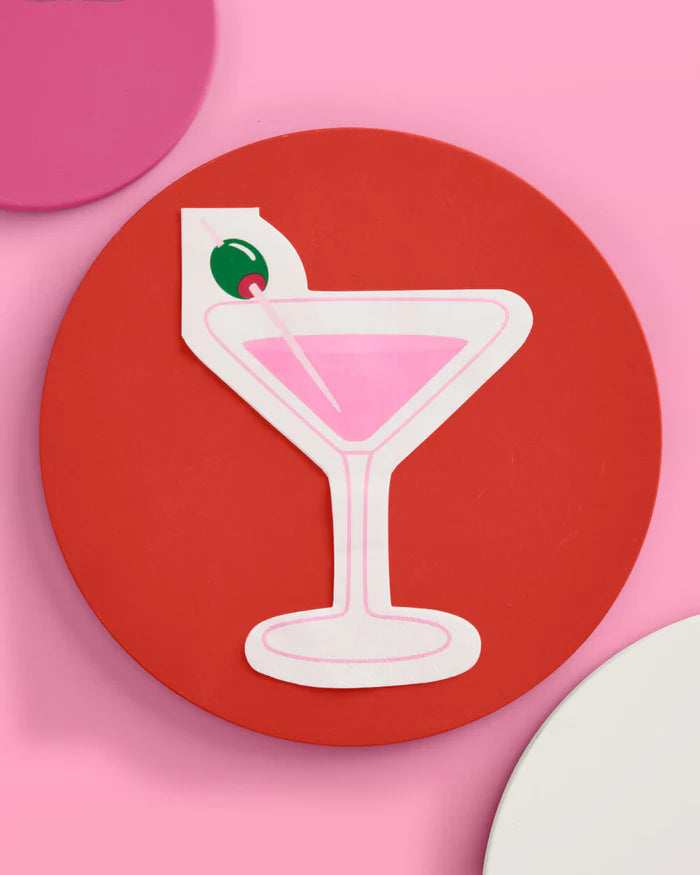 Single pink martini glass shaped cocktail napkin styled on a red plate with pink background