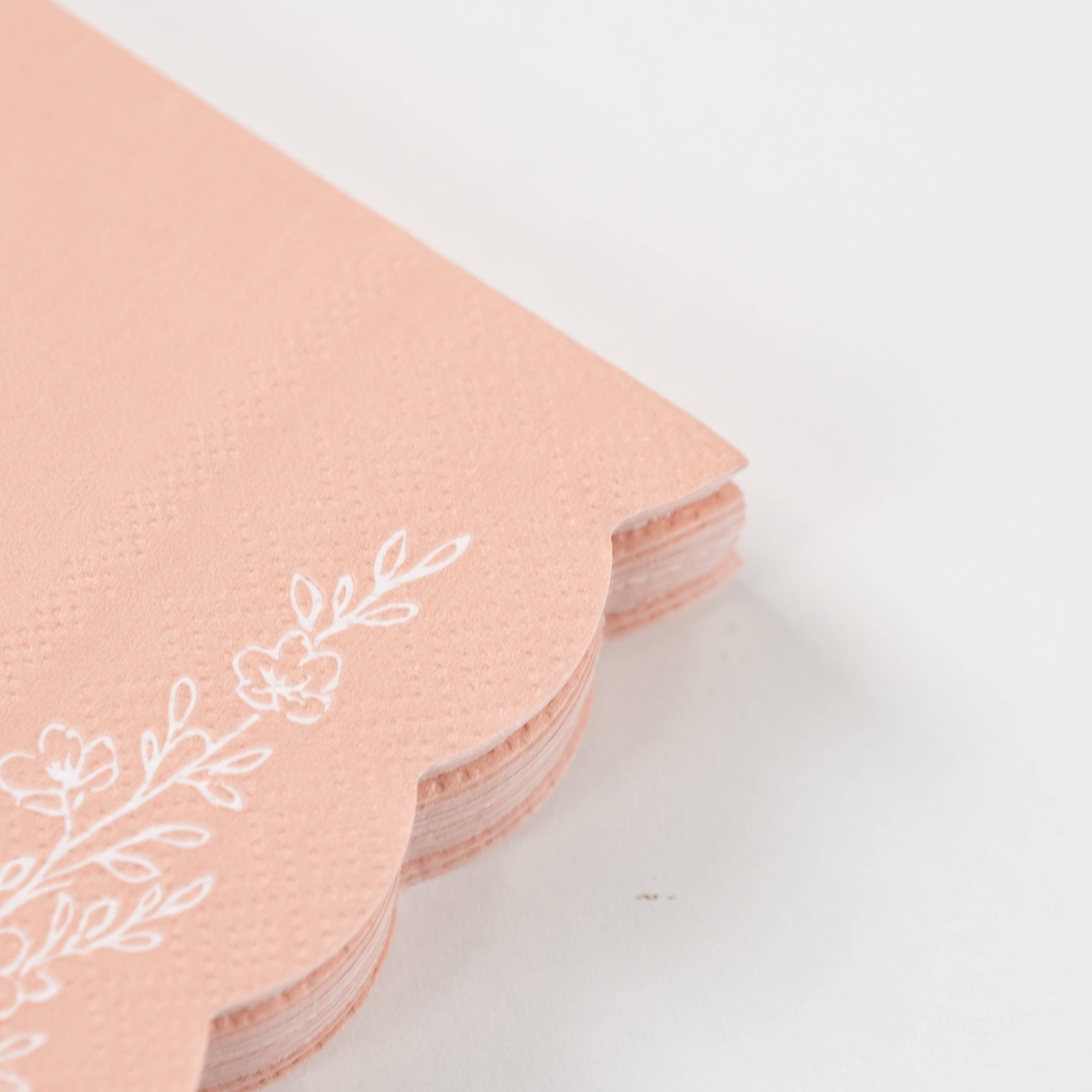 Close-up of stacked pink floral napkins with scalloped edges