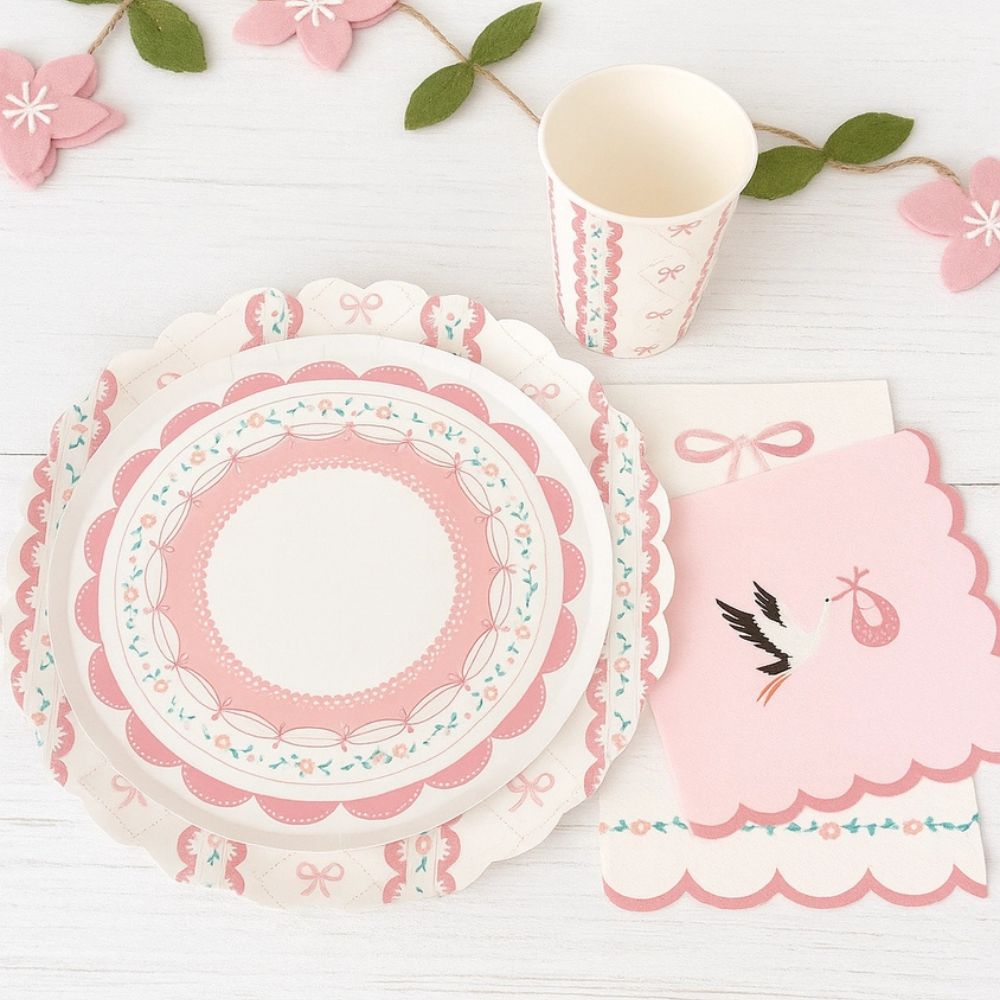 Pink baby shower setting with stork napkins and bow themed tableware