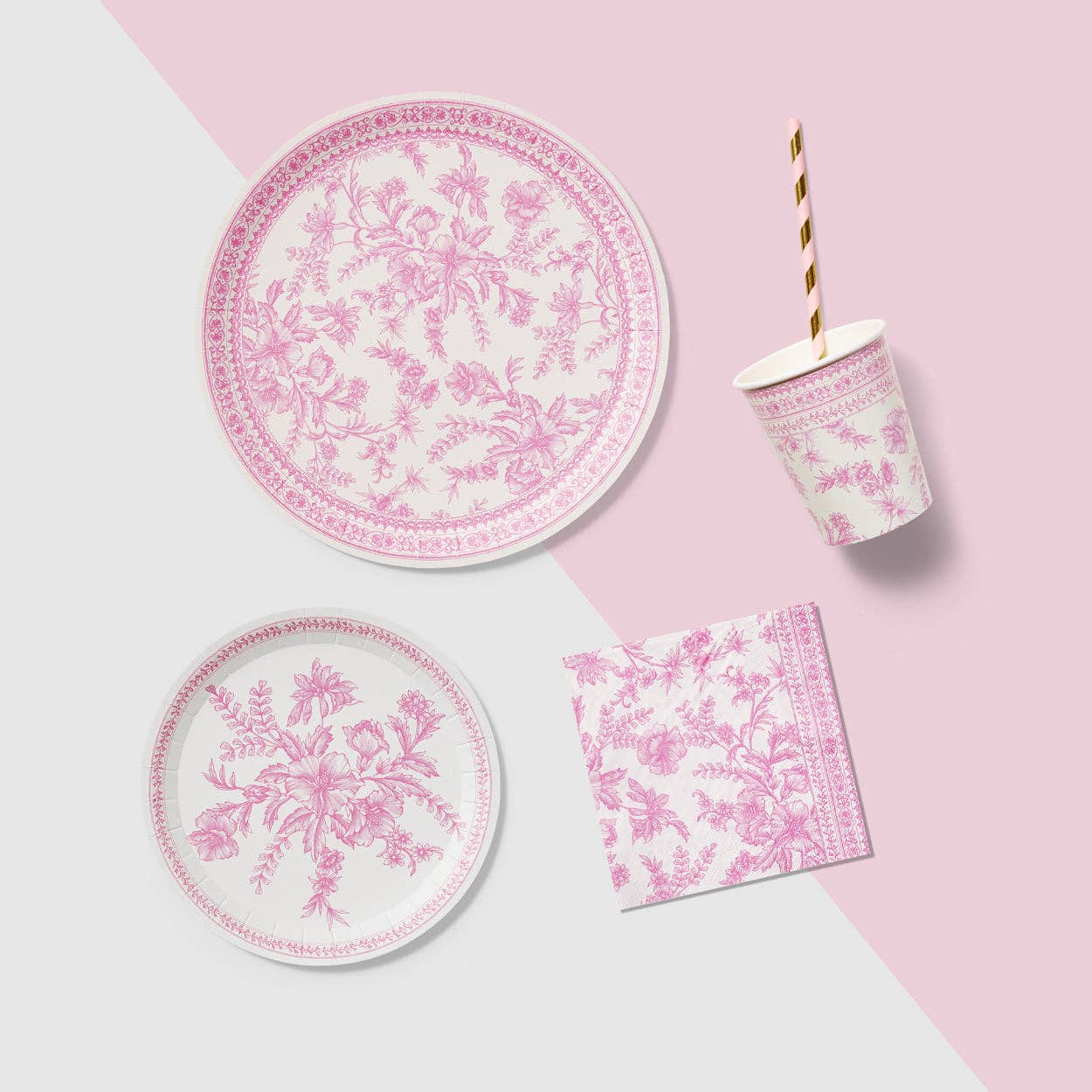 Pink toile plate with matching napkin and cup on styled background.