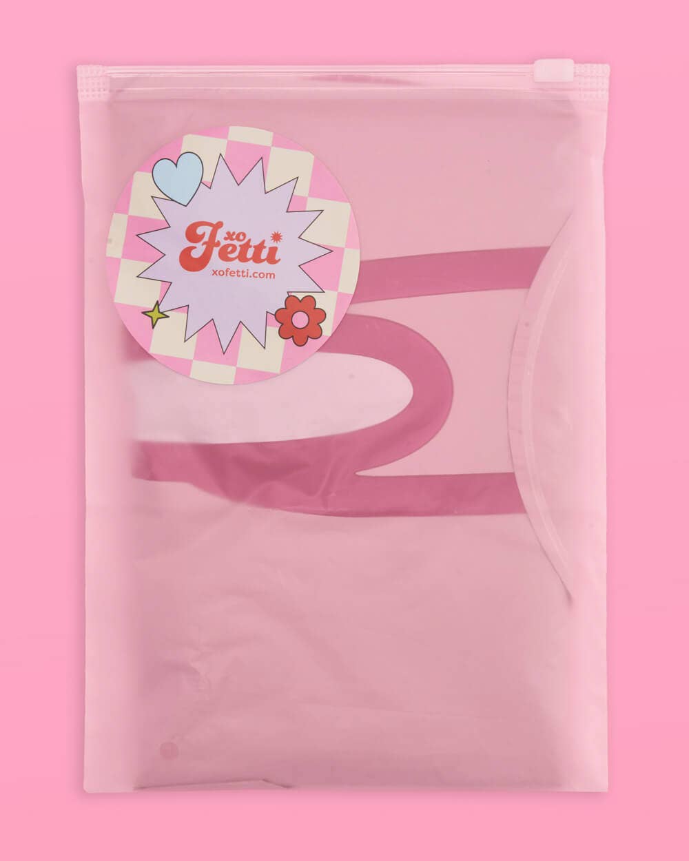 Ring finger diamond balloon in pink frosted packaging with xo Fetti brand sticker on pink background