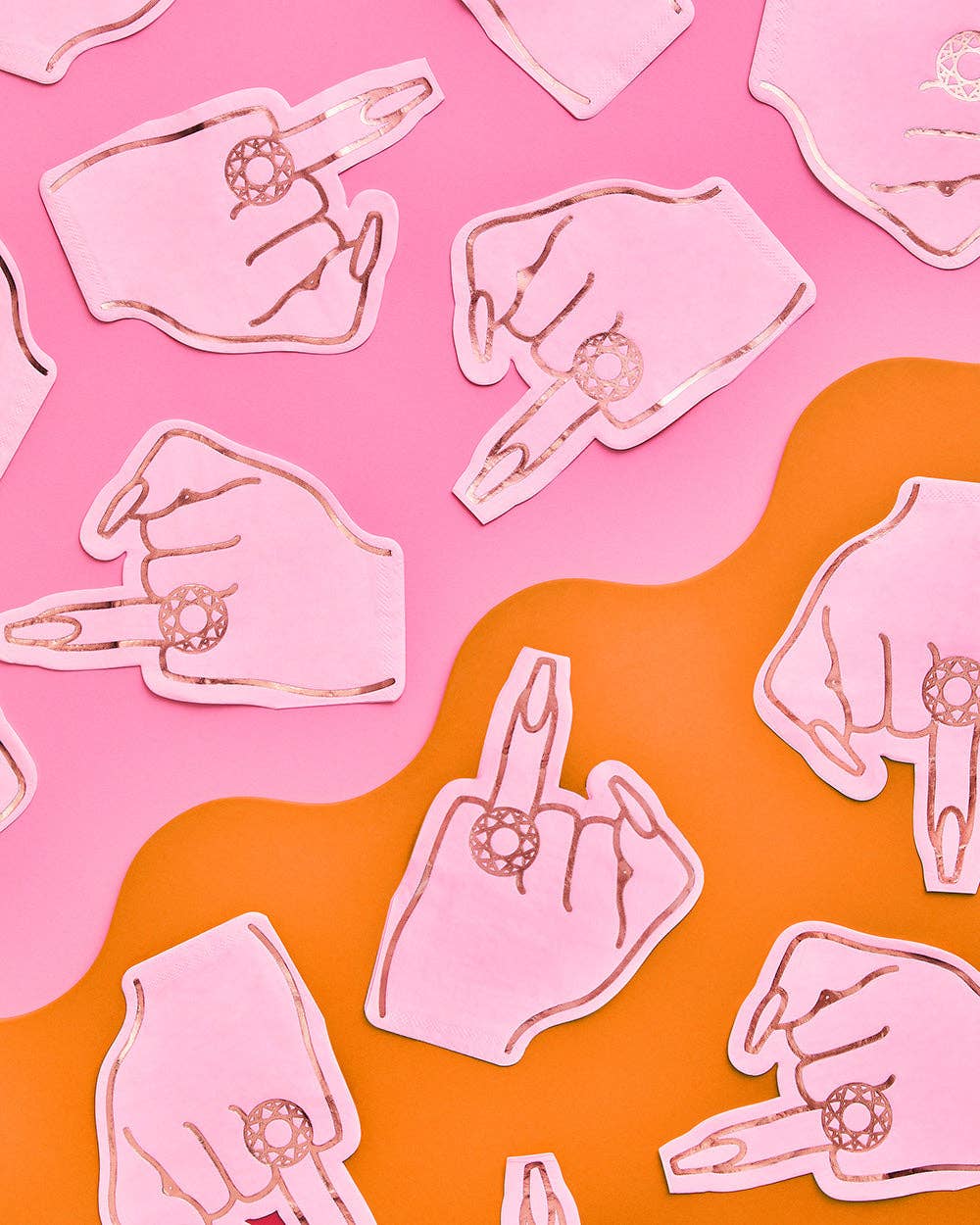 Single pink ring finger die-cut napkin on orange plate against pink background showing hand with diamond ring in hot pink foil
