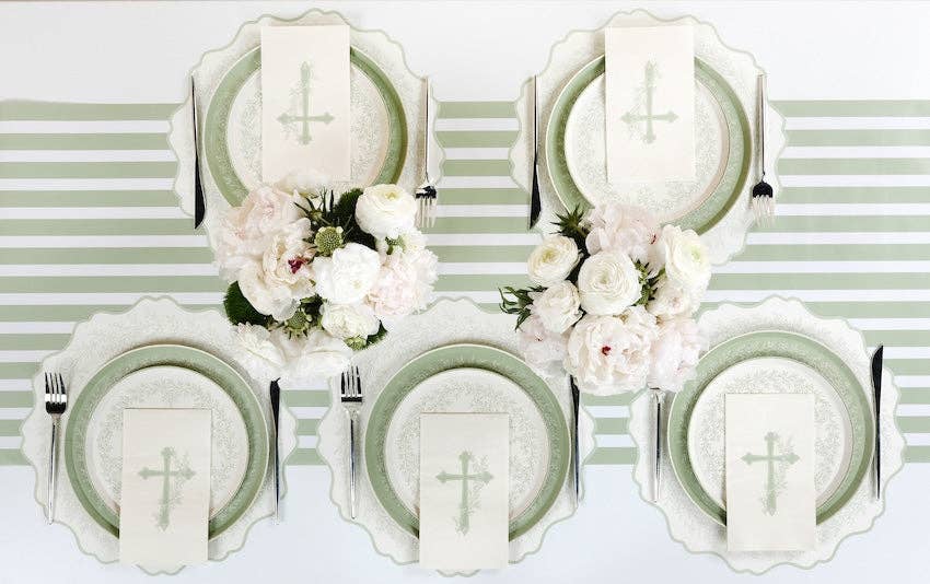 An ethereal easter table setting featuring four place settings with botanical cross napkins and sage lattice plates in a secret garden style.