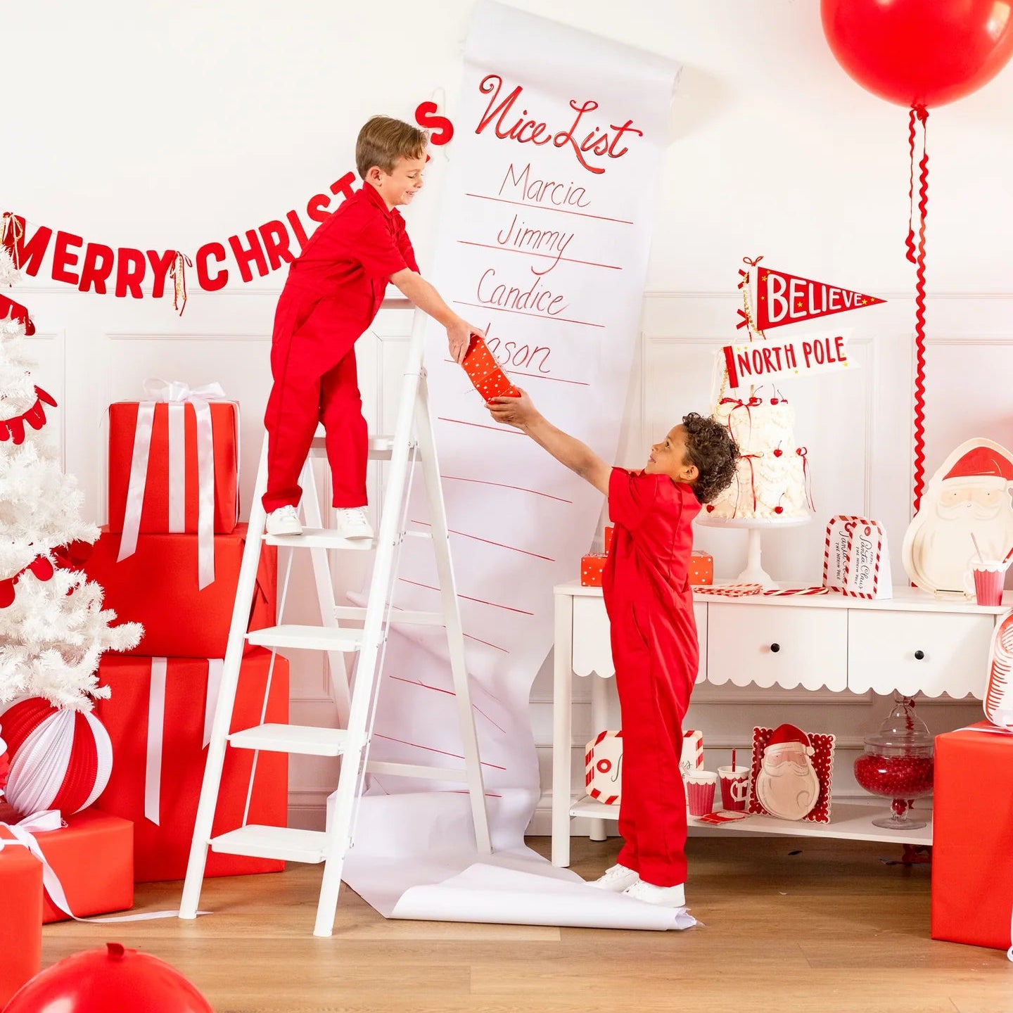 Holiday vignette with Nice List backdrop and assembled Santa Christmas cookie boxes on dessert table
