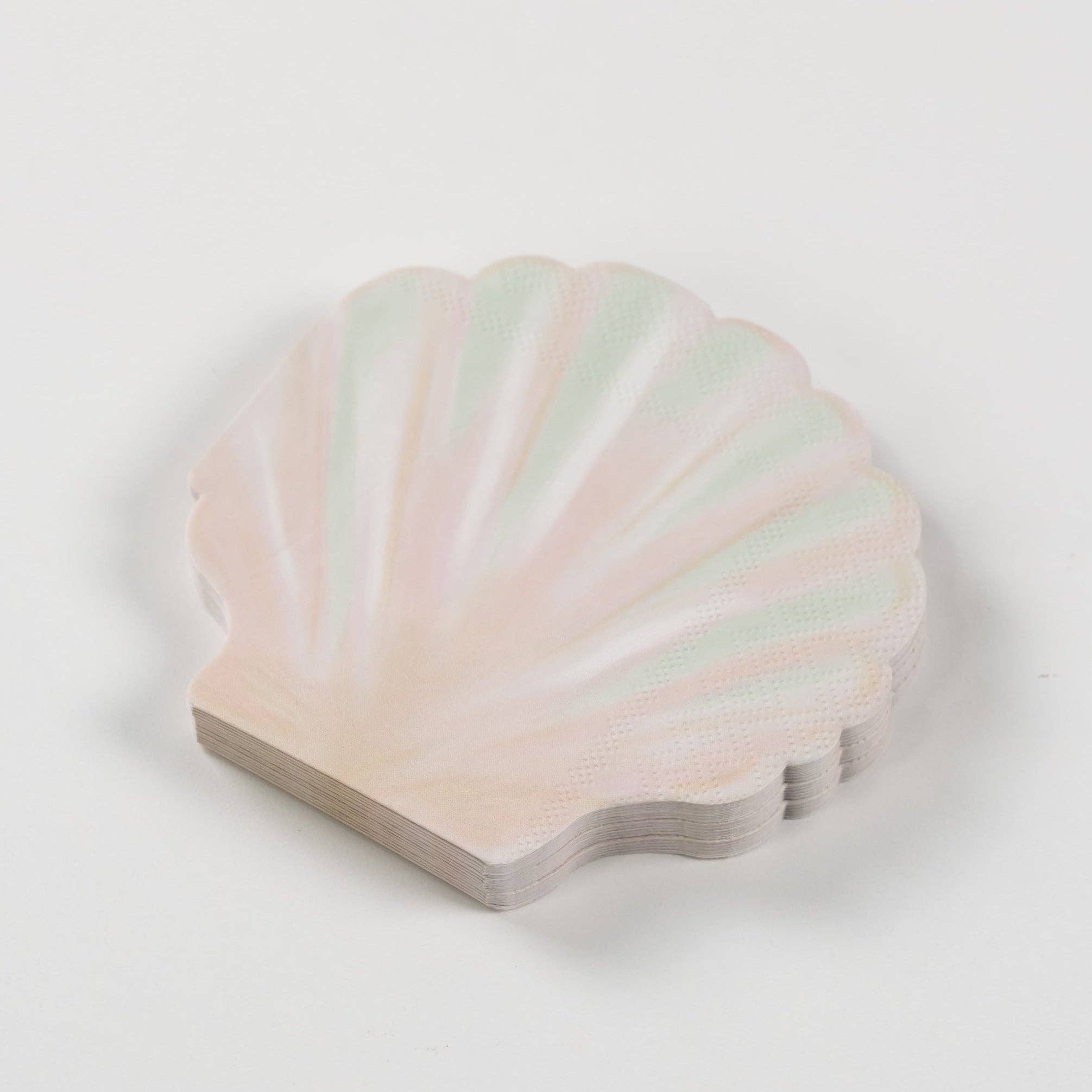 stack of seashell paper napkins showing shell shape and soft pastel tones.