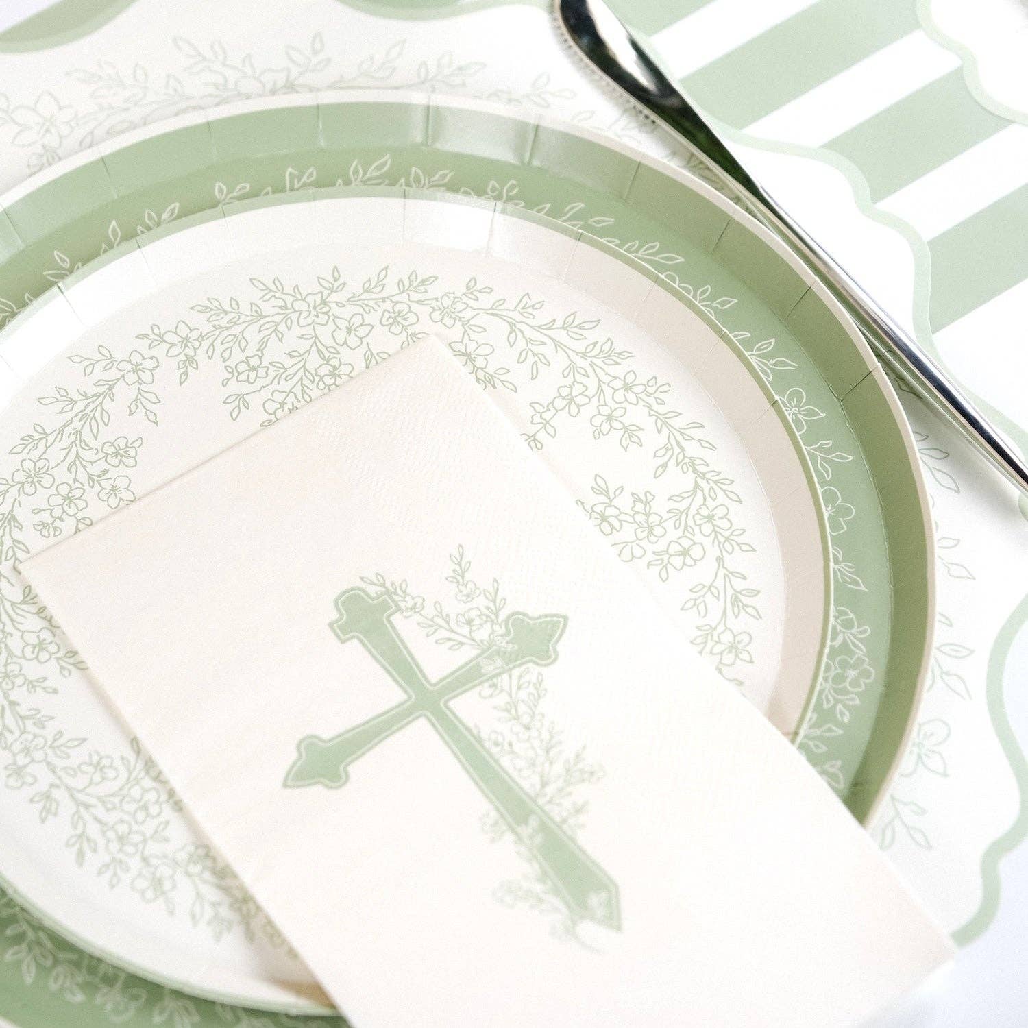 A curated Secret Garden table setting featuring Botanical Cross napkins and sage green lattice-edge plates.