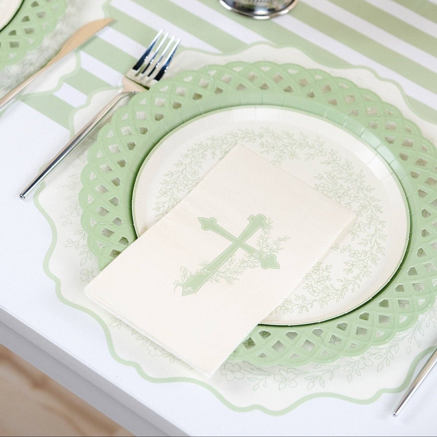 A serene secret garden table arrangement with white ranunculus centerpieces and botanical cross place settings.
