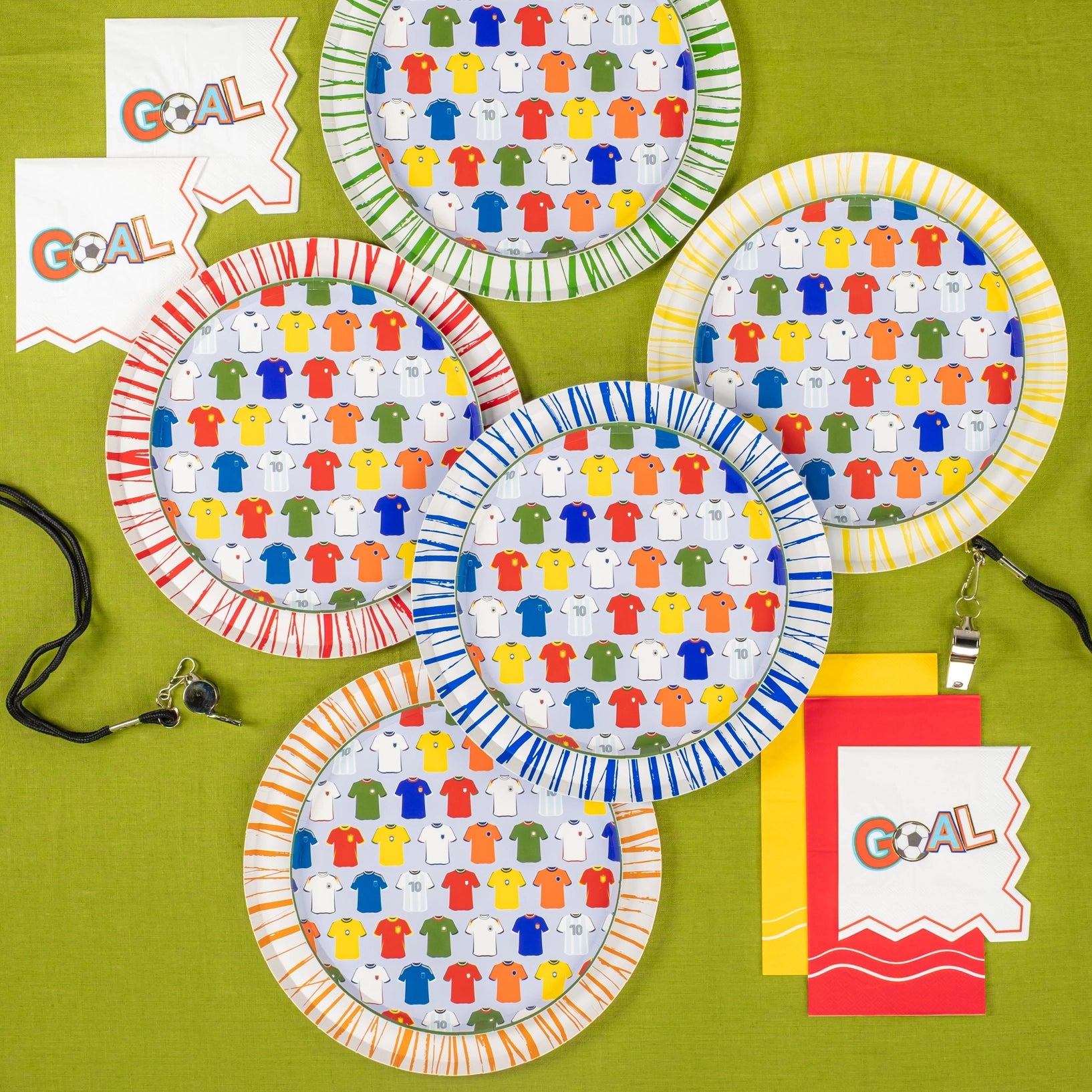 Flat lay of five plates with napkins and ref’s whistle