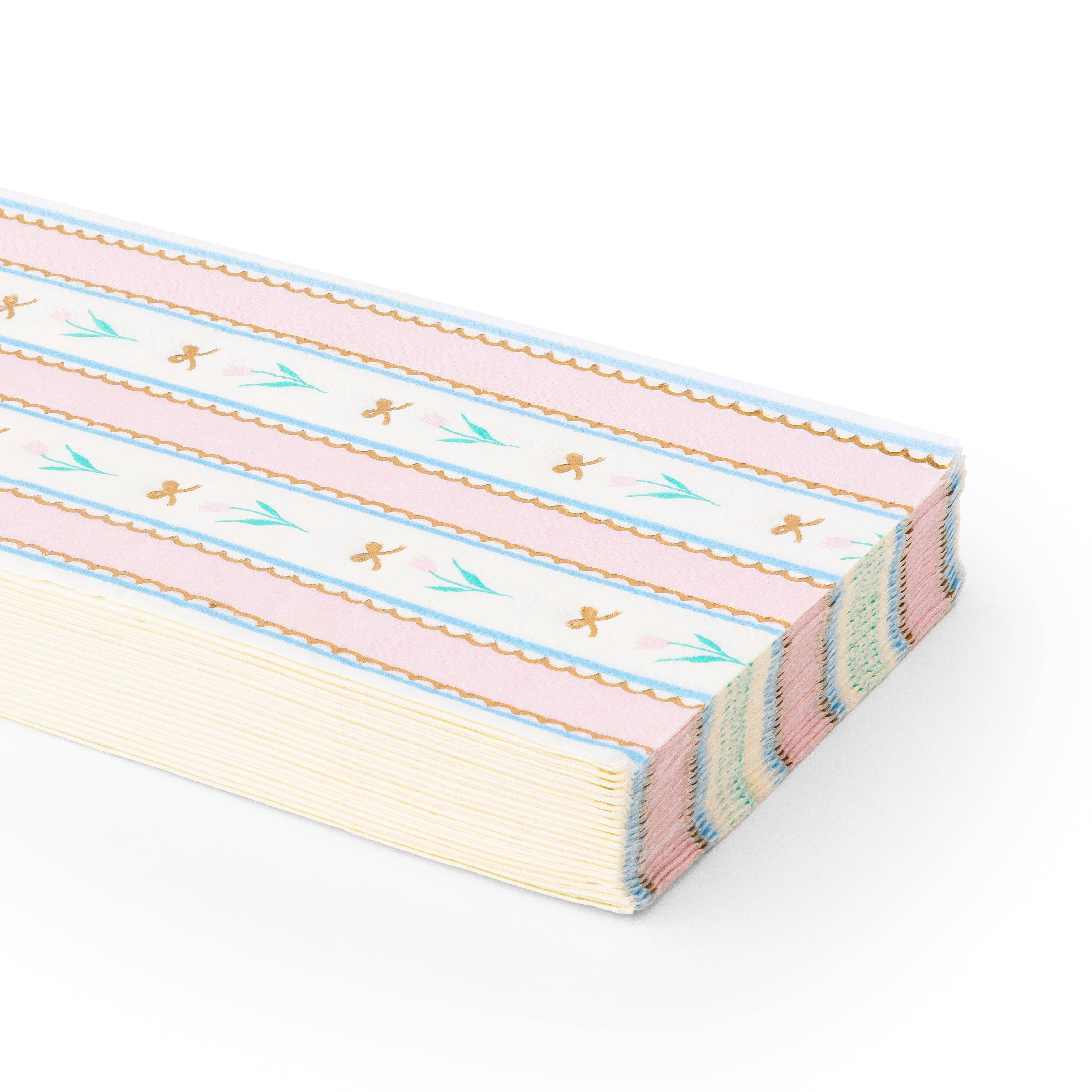 Stack of spring tulip guest towel napkins with pink stripe and floral design