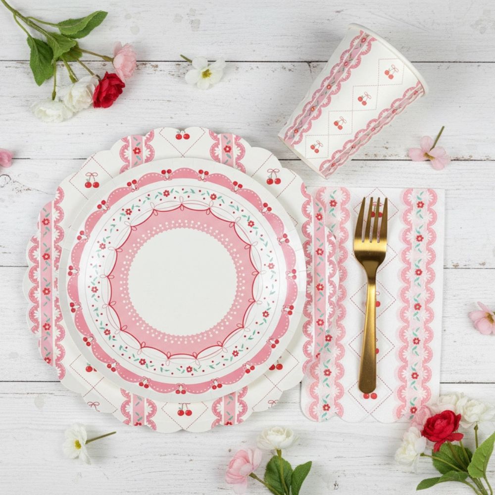 Layered place setting with a cherry dessert plate on top of a large charger