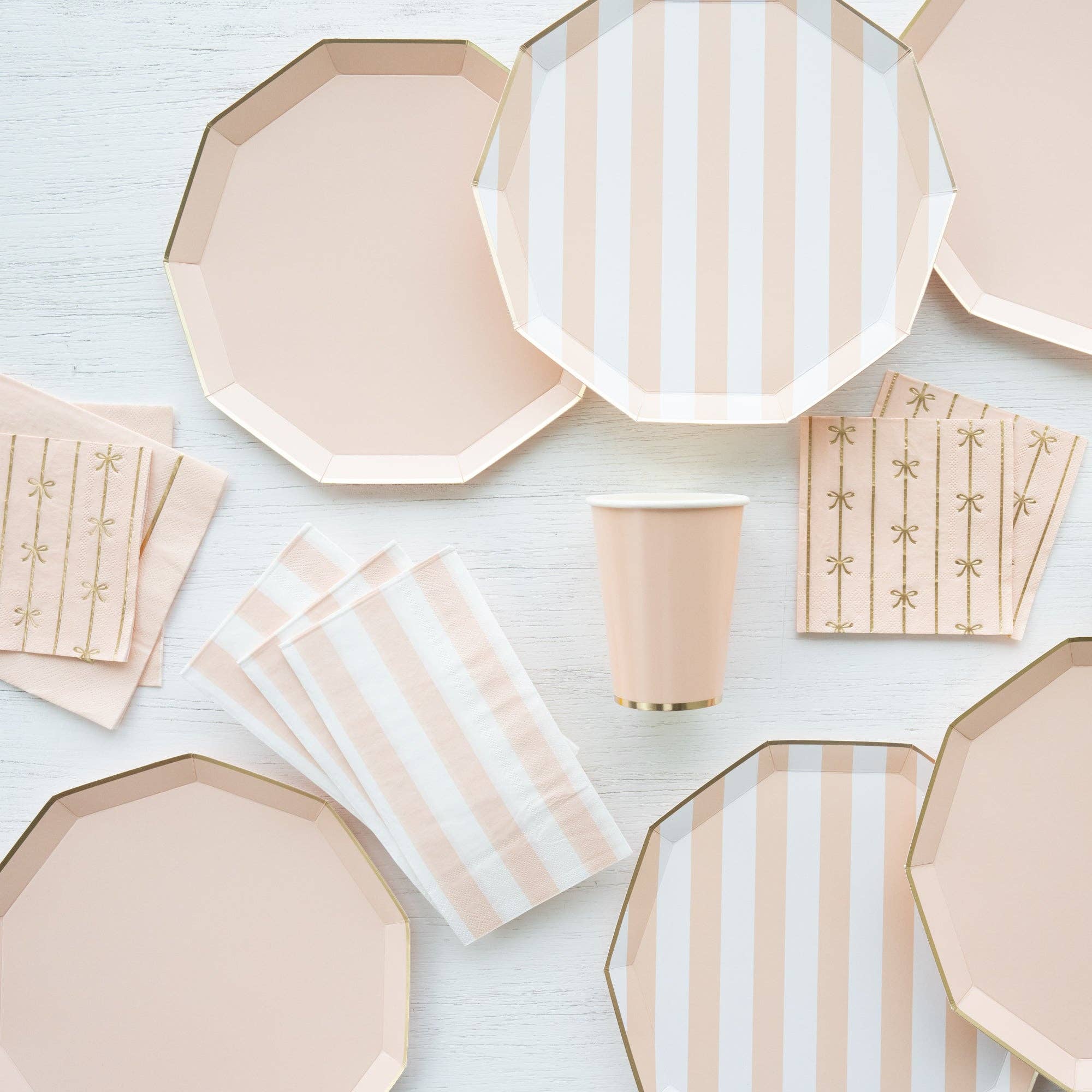 Sweet Peach napkins styled with matching plates, cups, and bow napkins in peach and gold tablescape setup