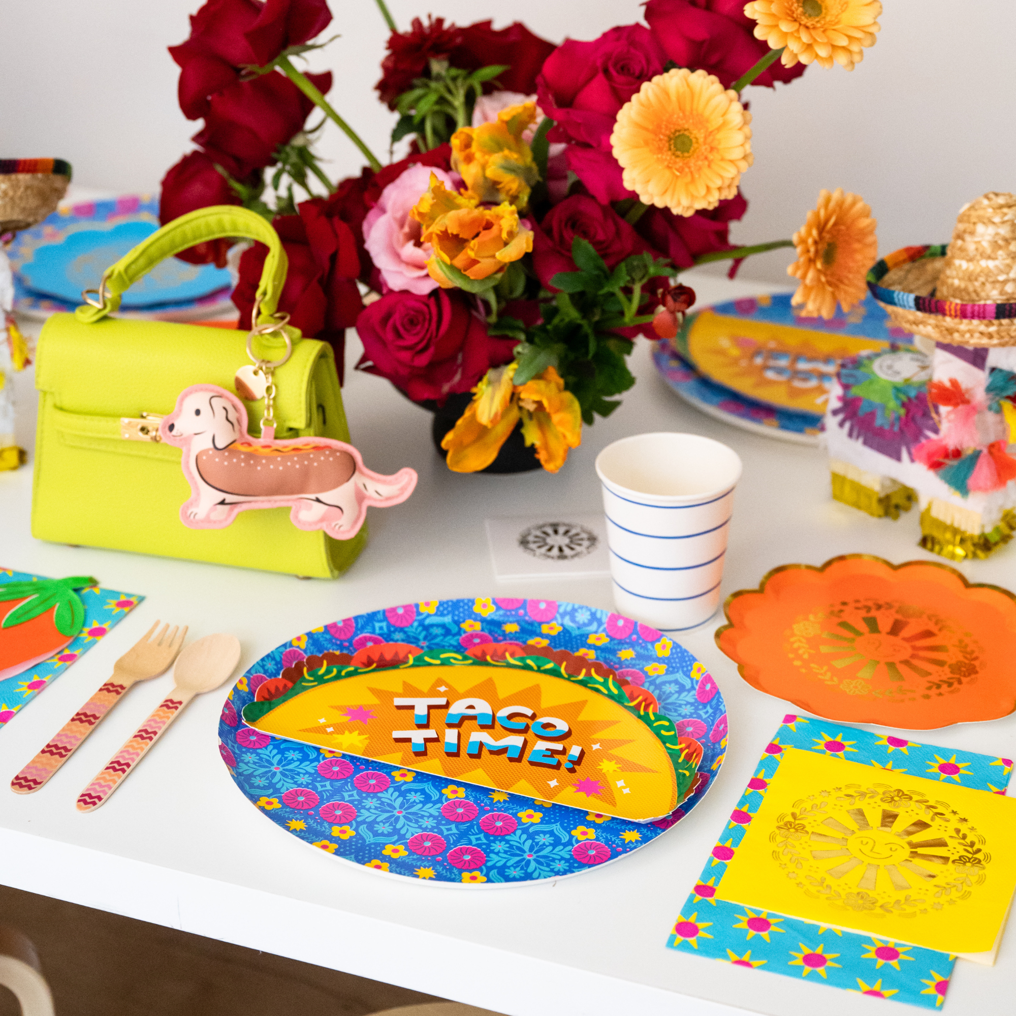 taco themed party table with taco plate flowers and colorful fiesta decorations
