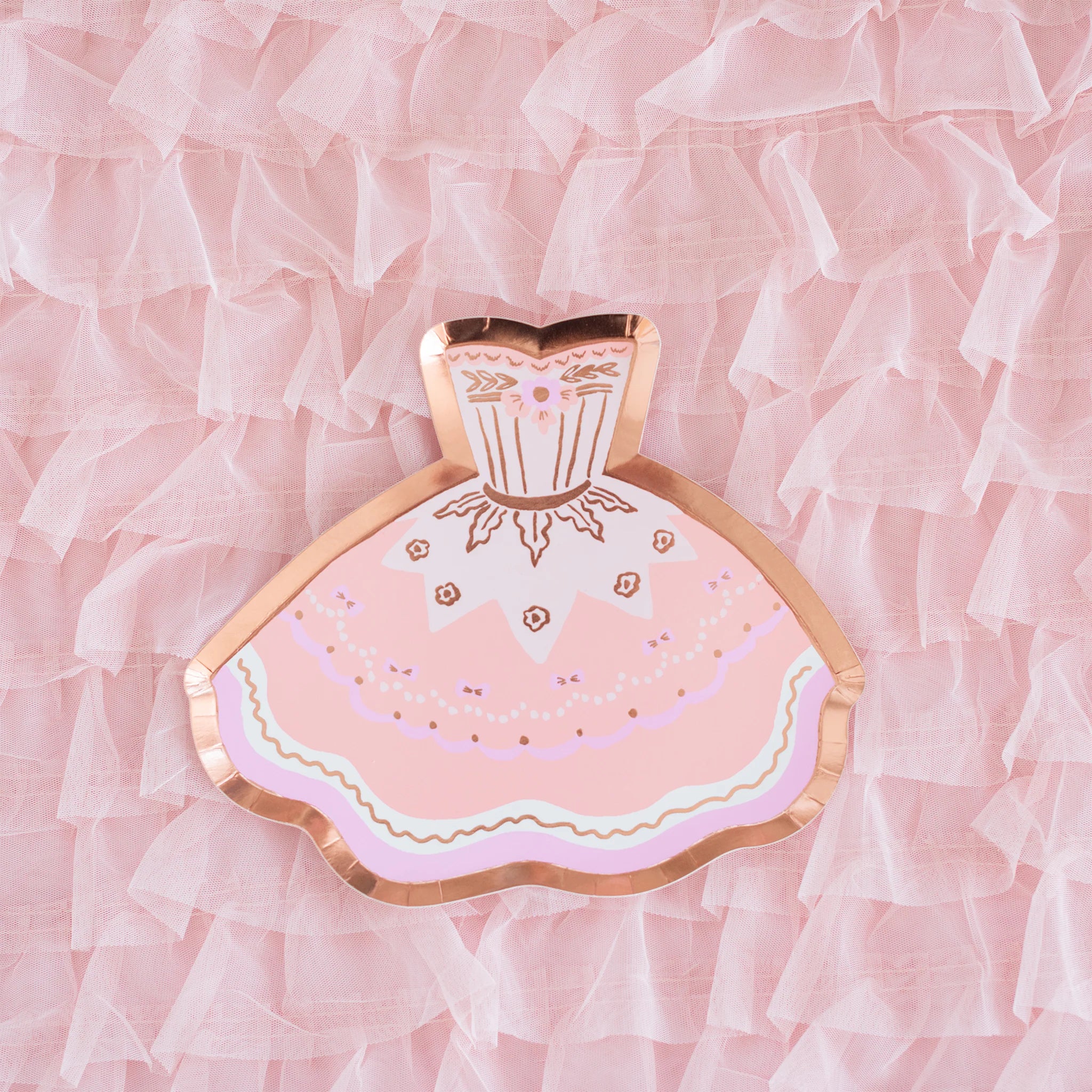 A single pink tutu-shaped paper plate with rose gold foil trim centered on a ruffled pink tulle background.