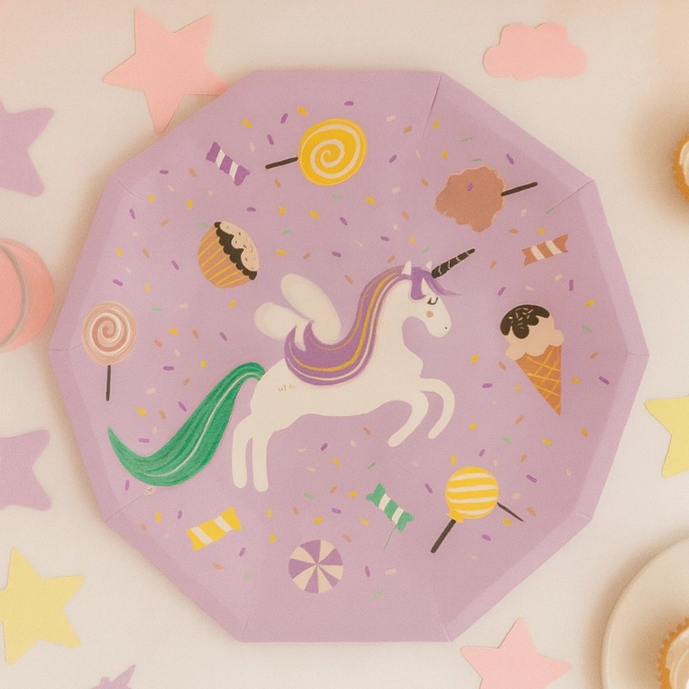 Close-up of a unicorn party plate on a white surface with star confetti