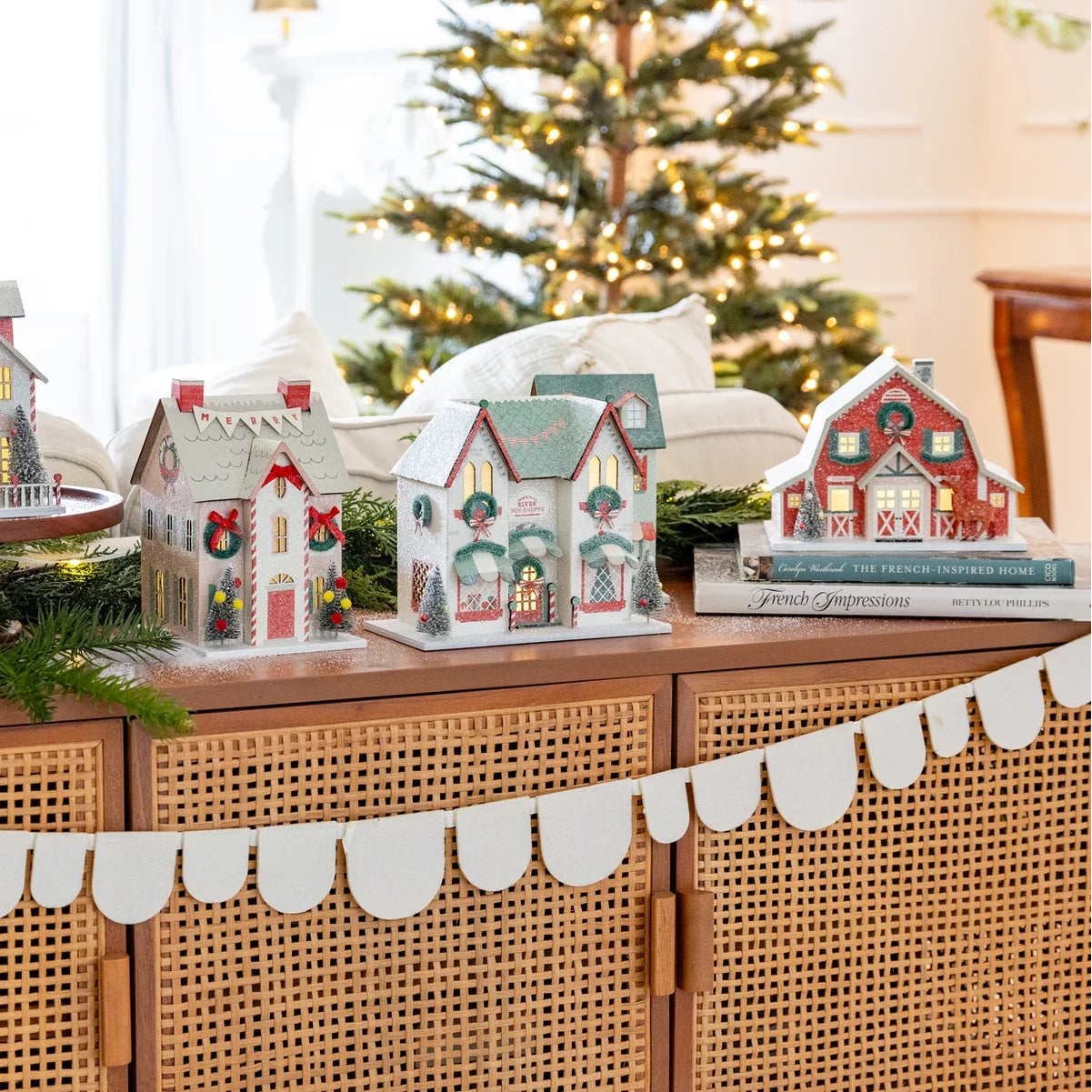 Wide shot of the entire Christmas village collection set up on a console table, featuring the Reindeer Barn decor prominently on the right.