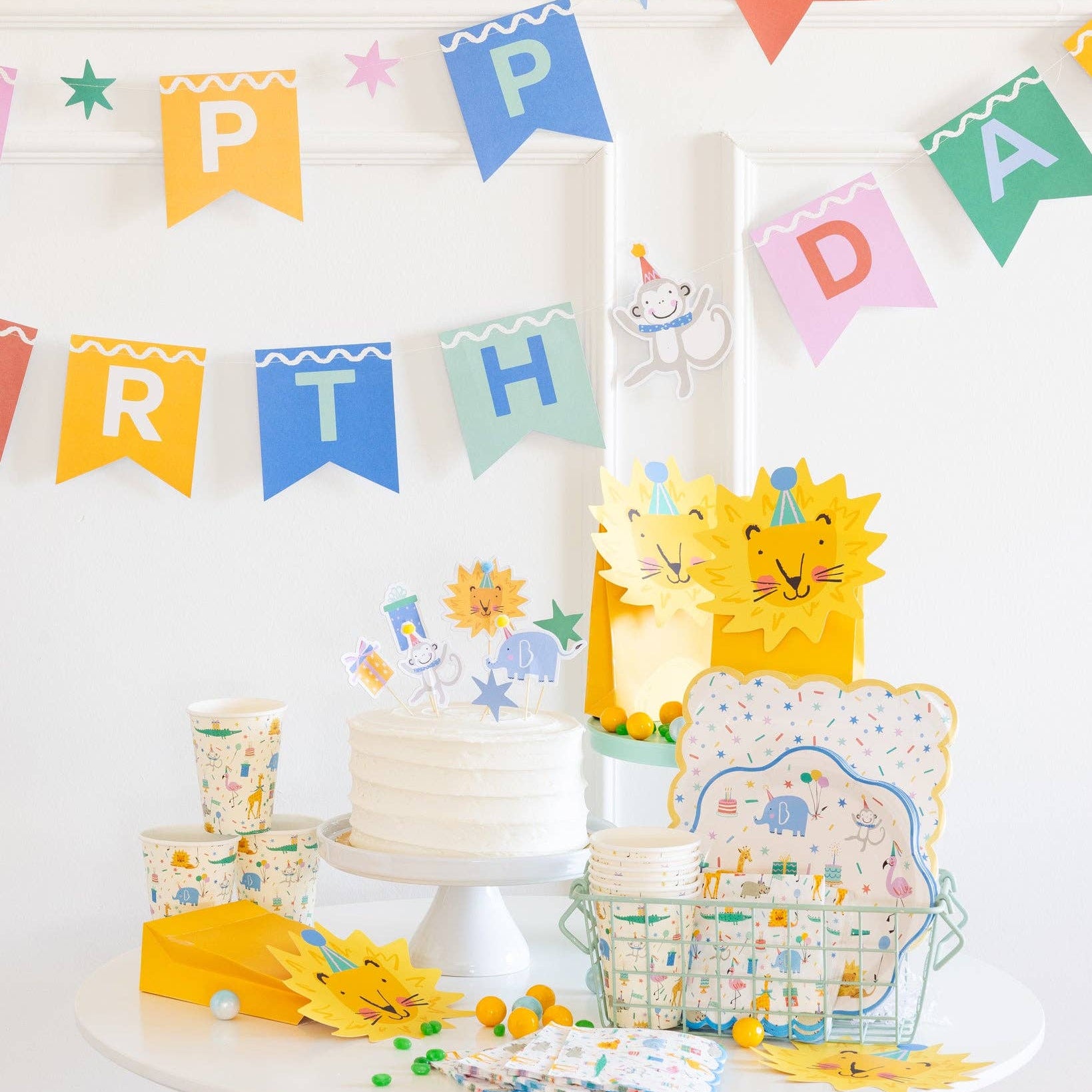 Wild One birthday party table with animal cups and cake
